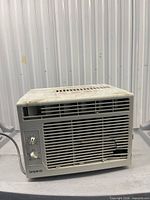 Front and side view showing overall unit, power cord, grille, and top surface