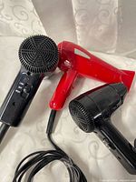 Three Conair travel hair dryers side by side