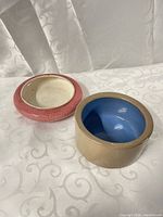 Both small ceramic pots side by side