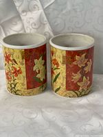 both cylindrical ceramic containers front view showing floral design