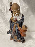 front view of glazed ceramic longevity figurine with child