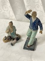 Both Shiwan mudmen figurines side by side on white backdrop