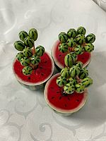 Three watermelon holders filled with decorative toothpicks