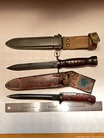 Both daggers with their scabbards displayed alongside 12-inch ruler for scale