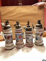 Front view of all four lithophane steins showing height, design and lids