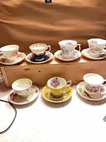 All seven teacup and saucer sets displayed