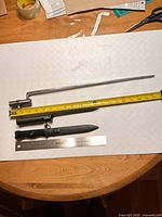 Both bayonets side by side with measuring tape and ruler for scale