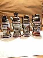 Front view of four regimental steins showing overall condition and decoration