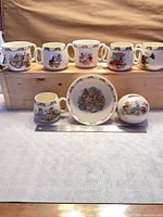 Full set: six double-handled mugs, one cup, one bowl, one money bank on ruler for scale