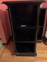 Full view of cabinet front showing shelves and carved details