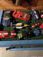 Top view showing group of die-cast cars on green base