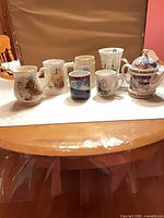 Group shot of all seven nautical themed mugs and stein on table