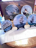 Front and back view of all five maritime plates on stands