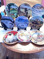 Group of decorative plates on stands and table