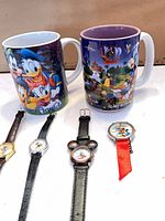 Group shot showing two mugs and five watches