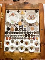 Overall view of shadow box with coins, badges, porcelain items