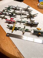 All 14 die-cast aircraft on tabletop with ruler for scale