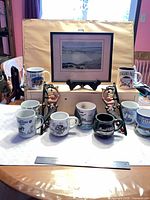 Group shot of framed print, mugs and brackets