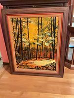 Full view of framed oil painting leaning against wall