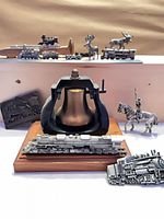 Group shot showing bell, pewter locomotives, railcars, belt buckle, plaque