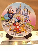 Front view of porcelain plate showing multicolor Disney character artwork and "25 Years" text