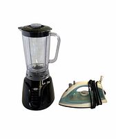 Blender with clear pitcher and lid beside corded blue-white steam iron