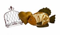 Fish sculpture, gold heart ornament, and red wire rack displayed together