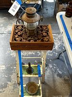 Lantern on carved tray atop step stool with candlestick and dish visible