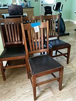 front view of four matching wooden slat-back dining chairs