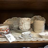 Shelf view showing stacked bowls, plates, Japanese cups and platters