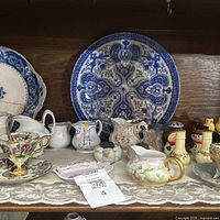 shelf view with charger plate and assorted porcelain pieces