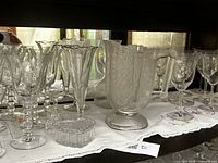 Multiple crystal stemware pieces, pressed glass pitcher, heart box on shelf