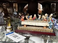 Overall shot showing Last Supper figurine and angel figures on glass shelf