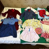 Overview of twelve vintage toddler garments and accessories laid out on bed