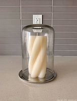 glass cloche over twisted ivory candle on countertop