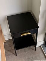 angled top and side view of black nightstand