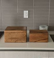Large and small solid wood boxes closed on countertop