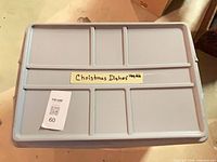 Plastic tote containing boxed Nikko Happy Holidays serving pieces