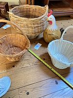 Group view of three wicker baskets and ceramic turkey figurine on wooden floor with tape measure for scale