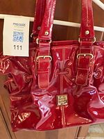 Front view of red patent leather Dooney & Bourke tote with lot tag visible