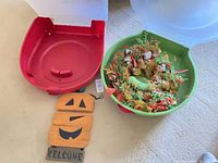 Overview of wreath in green box, red box half, wooden pumpkin sign