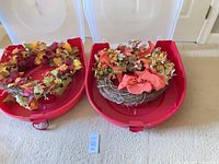 Both wreaths inside their red plastic storage bins