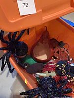 overview of bin contents including glitter spiders, gourd jack-o’-lantern bowl, flat pumpkin sign, bat cutout and garland