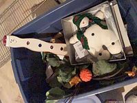 Overall tote contents with snowman items, pumpkins and greenery visible