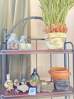 Shelves with faux plant, jars of acorns, candles and various decor items