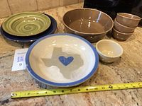 Group shot showing all nine ceramic pieces with tape measure for scale