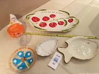 Group shot showing all six serveware pieces with measuring tape for scale