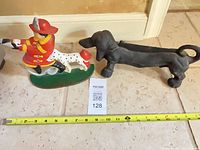 Both cast iron doorstops with measuring tape for scale