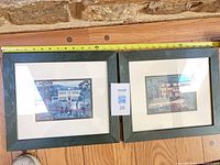 Both framed prints side by side with tape measure for scale