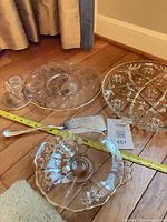 Overall lot showing three glass serving pieces, candlestick and metal server